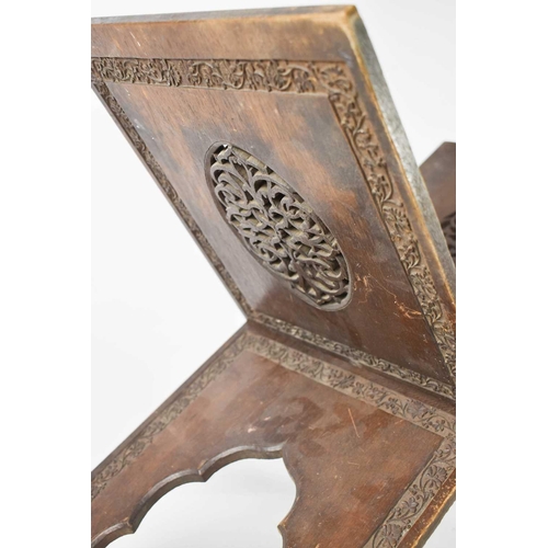 157 - A late 19th century hardwood folding Quran stand, with pierced decorative ovals and fret-carved bord... 