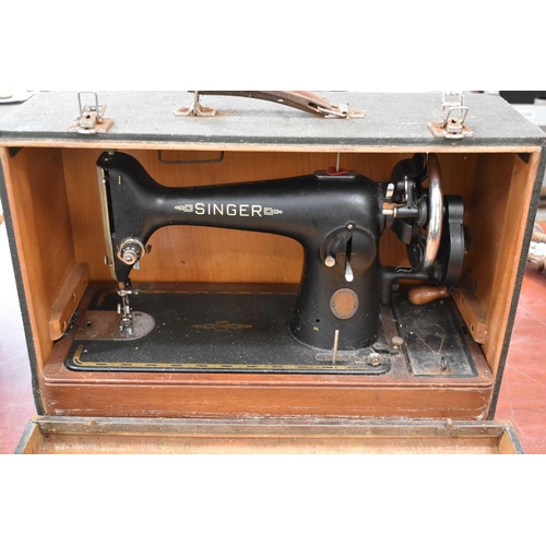 166 - A vintage Singer sewing machine, hand crank, with original carry case.