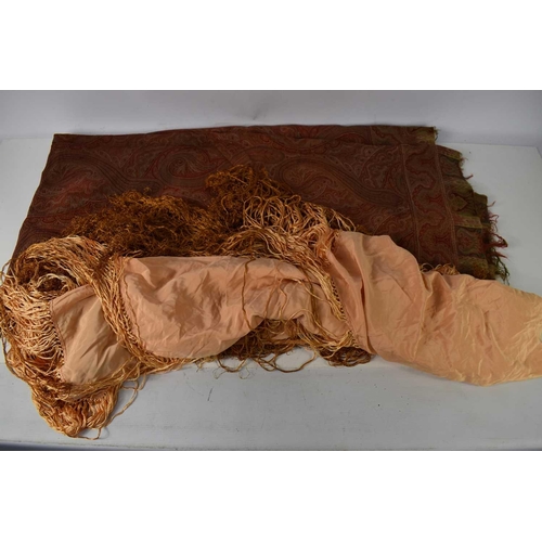 176 - A 19th century wool Paisley shawl, 182 by 171cm and a later peach silk piano shawl with fringe.