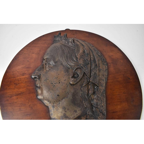 243 - A 19th century Queen Victoria relief cast metal portrait on mahogany roundel, 1937 VR 1897 plaque be... 