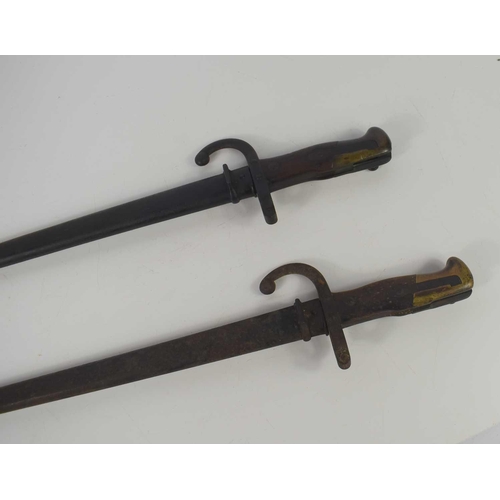 30 - Two French model 1874 bayonets, one marked St Etienne and dated 1876, both with scabbards.