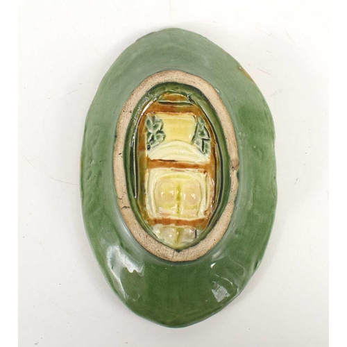 412 - A Majolica green glazed dish, depicting a man on a ladder picking fruit from a tree, the reverse mod... 