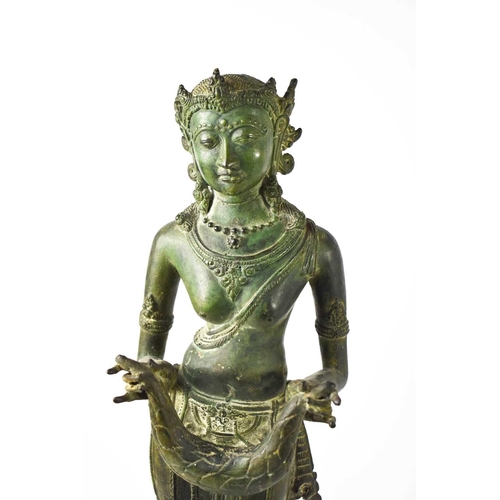 436 - An early 19th century bronze bodhisattva figurine, with green patination, depicted holding a garland... 