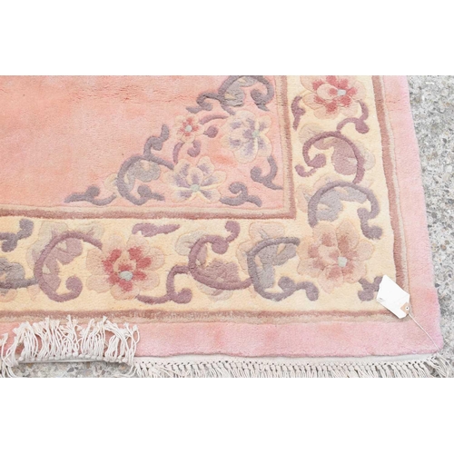 518 - Two Chinese wool rugs, in pastel shades, both with foliate scroll borders, 183cm by 270cm and 156cm ... 