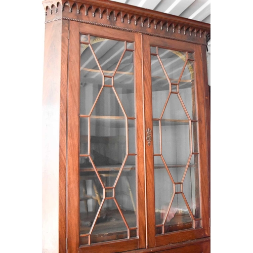 525 - An unusual 19th century mahogany corner cupboard, the astragal glazed doors enclosing a shaped shelv... 