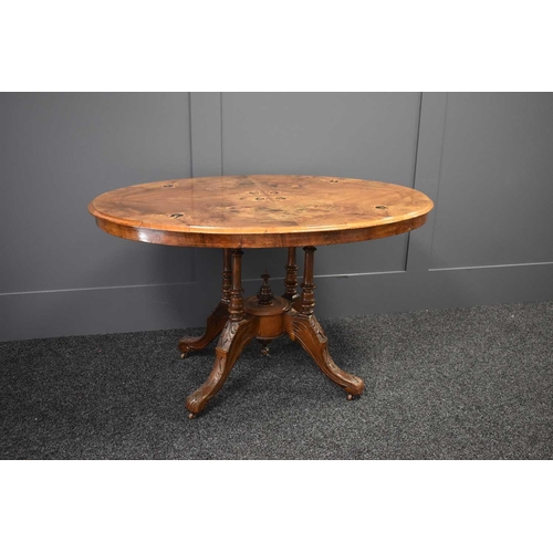 526 - A Victorian walnut marquetry inlaid breakfast table raised on four turned columns united by a centra... 