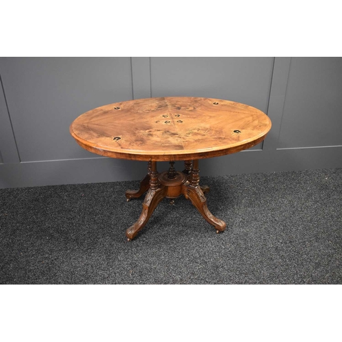 526 - A Victorian walnut marquetry inlaid breakfast table raised on four turned columns united by a centra... 