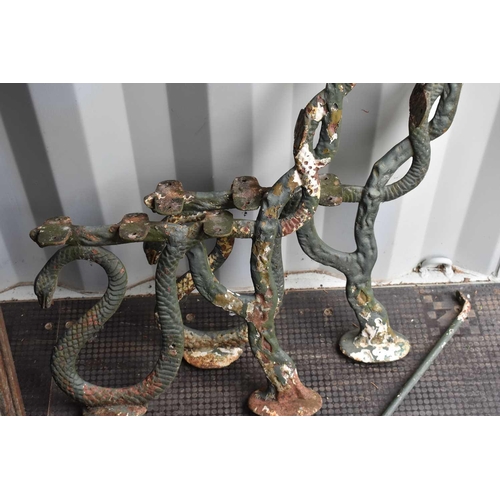 539 - A pair of cast iron and painted bench ends in the form of serpents or snakes.