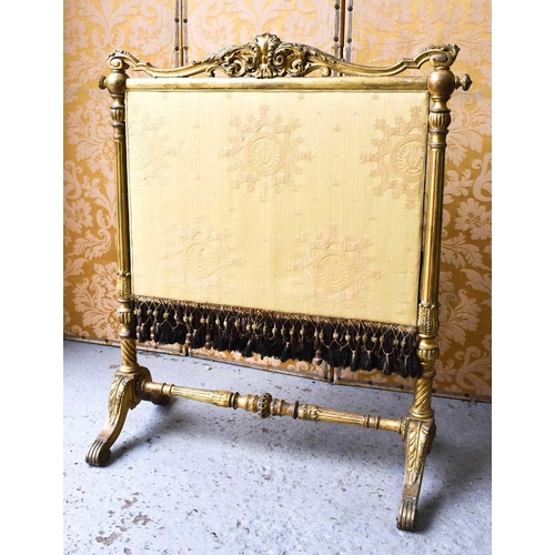 545 - A 19th century country house fire screen, the carved and gilded frame housing a cream upholstered sc... 