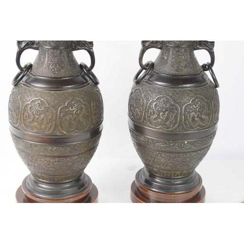 101 - A pair of Chinese bronze table lamps, 20th century, cast with decoration to depict dragons, turtles,... 