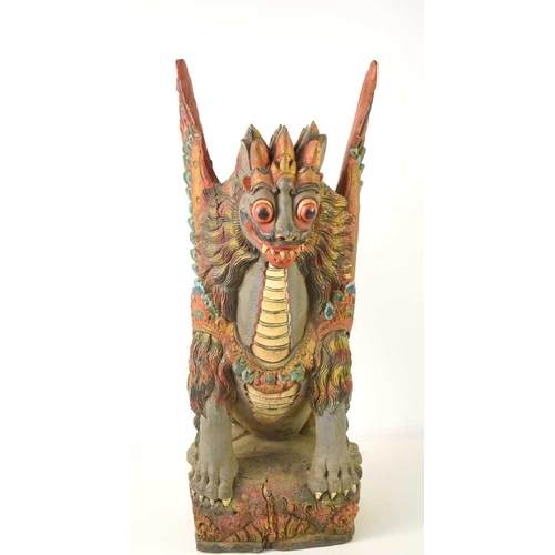 102 - A Balinese polychrome and gilt wood sculpture of a winged lion, early 20th century, 59cm high.