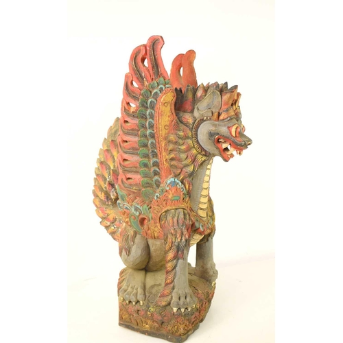 102 - A Balinese polychrome and gilt wood sculpture of a winged lion, early 20th century, 59cm high.