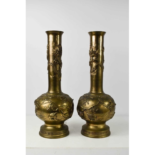 106 - A pair of Chinese bronze vases, the bodies decorated with waterfowl amongst reeds and prunus blossom... 