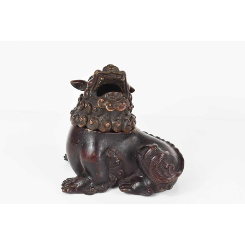 111 - An early bronze dog of fo, with red patination, with impressed calligraphy mark to the underside, mo... 