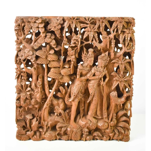 149 - An intricate Balinese carving depicting a courting couple in a forest, 37 by 34cm.