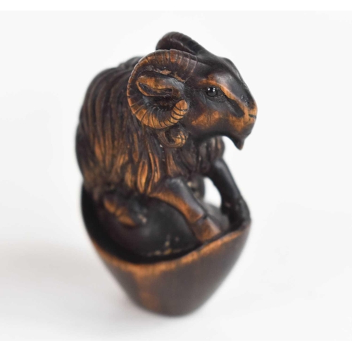 157 - A Japanese carved wooden netsuke of a ram, with glass eyes and signed mother of pearl button to the ... 