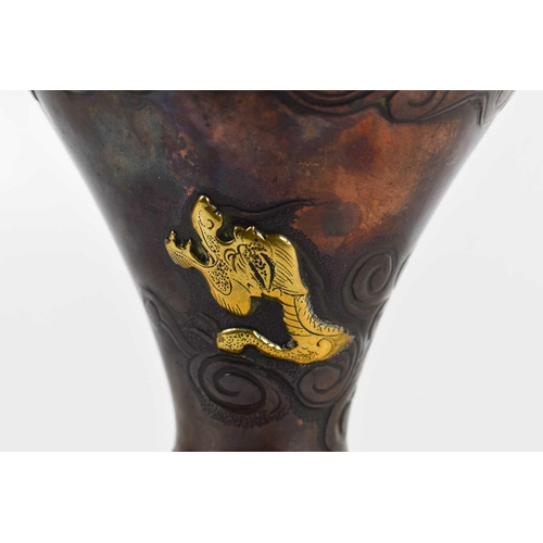 16 - A Chinese copper bronze flared vase of flared baluster form, with rivetted gold coloured dragon deco... 