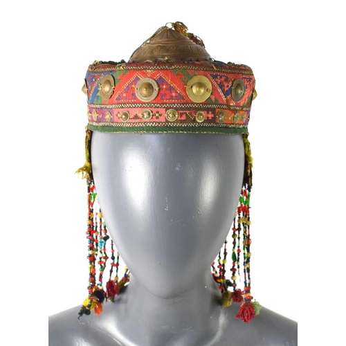 195 - A 19th century embroidered and beaded hat, likely Anatolian, with applied chain and shields, with em... 