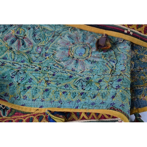 196 - A North West Chinese or Tibetan linen pelmet hanging, of band and pennant form with polychrome crewe... 