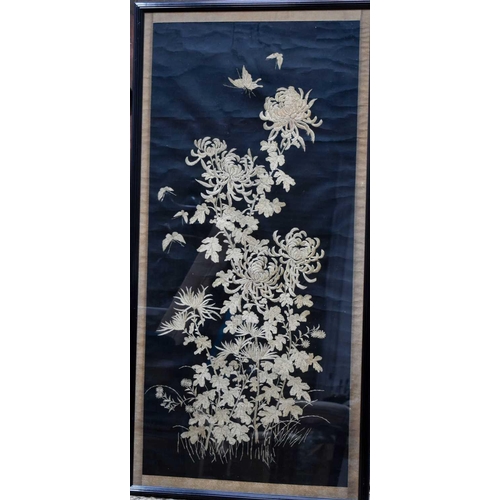 221 - A large Chinese embroidered panel, depicting butterflies amidst lotus flowers, on a black ground, 11... 