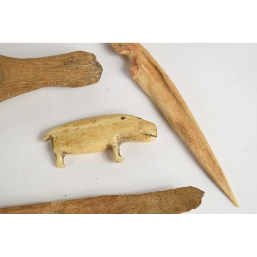 299 - A 19th century Native American Inuit carved bone seal sculpture together with various bone tools and... 