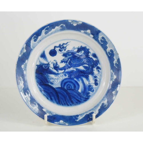 31 - A 19th century Qing period blue and white Chinese dish, depicting a dragon chasing a flaming pearl, ... 