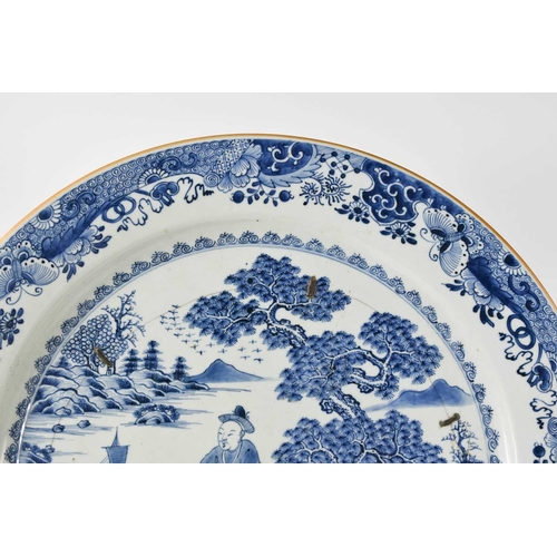 33 - An early 19th century Chinese blue and white charger, depicting a figure standing beside a tree with... 