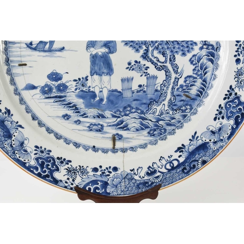 33 - An early 19th century Chinese blue and white charger, depicting a figure standing beside a tree with... 