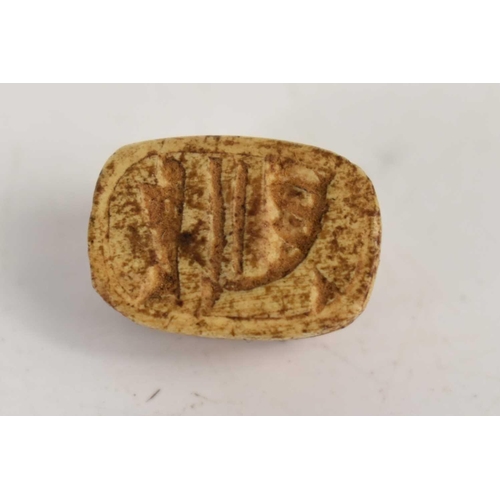 361 - An antique carved bone scarab beetle toggle or bead, the base carved with hieroglyphs, 1cm by 1.5cm.