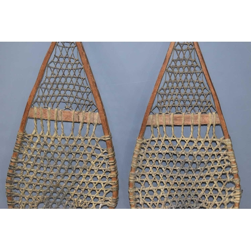 379 - A pair of early 20th century Native American snowshoes, the shoes feature a woven lattice work of ra... 