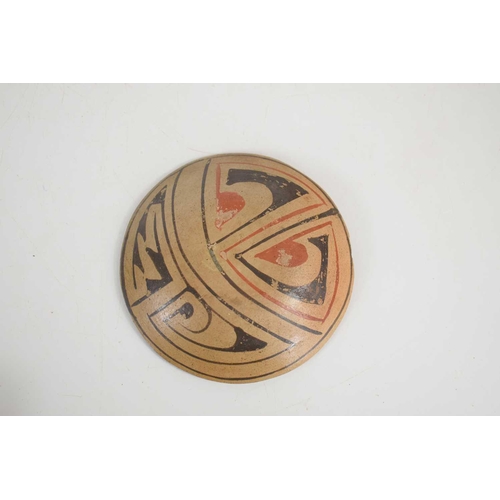 383 - A Pre-Columbian Casas Grandes pottery dish with black and red painted decoration, 10cm diameter.