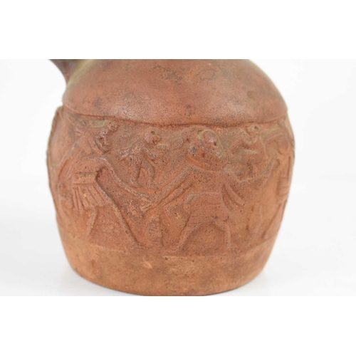 398 - A Pre-Columbian stoneware jug with relief moulding depicting figures dancing, 19cm high.