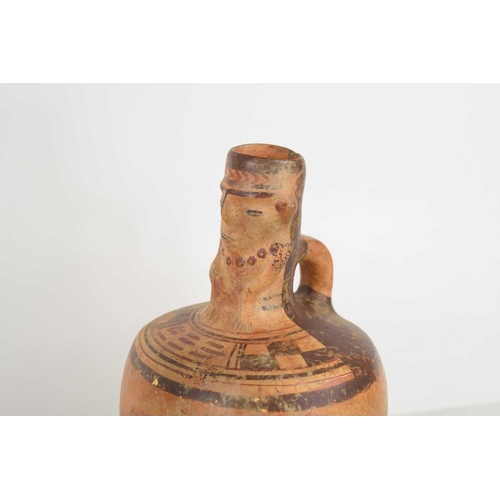 411 - A Pre-Columbian potter vessel / pitcher, the neck depicting a seated figure, painted stylised patter... 