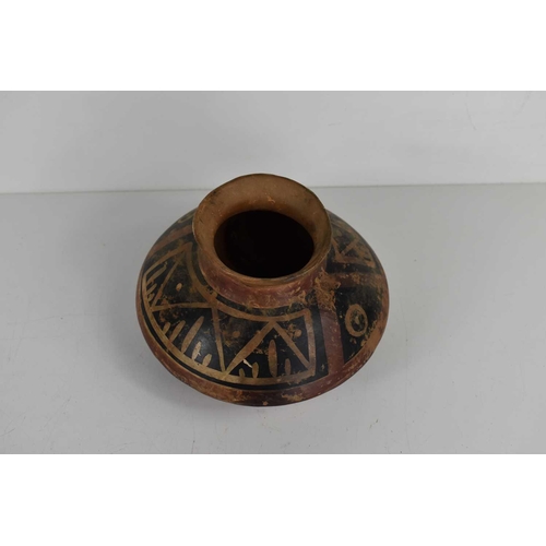 424 - A Native American clay pottery pot of bulbous form, with geometric decoration. 9.5cm high.