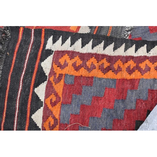 437 - Two early 20th century Middle eastern kilim rugs, with red, orange, black and white geometric patter... 