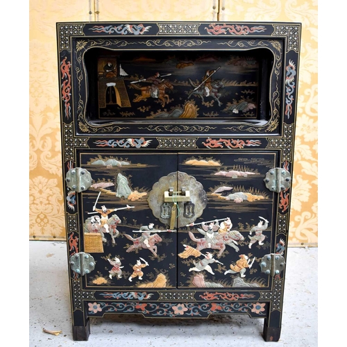 447 - A Chinese cabinet with two doors, shelf, and open shelved compartment, decorated with warriors, with... 