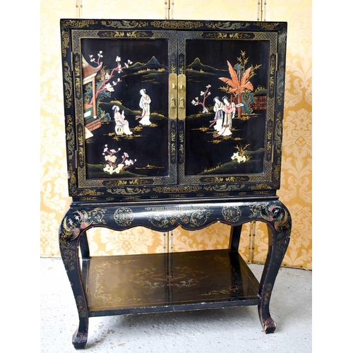 453 - A Chinese black lacquered cabinet on stand, Chinoiserie decorated scenes to outer and inner door pan... 