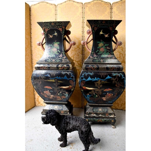 454 - A large and impressive pair of 19th century papier mache black lacquered vases, raised on wooden mat... 