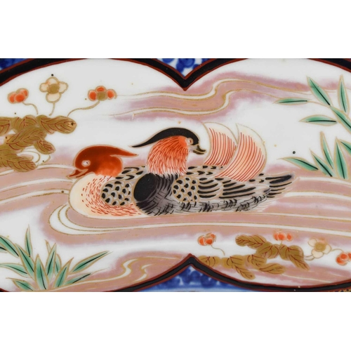 5 - An Edo period Imari charger, the central circular panel with and artist painting a fire-bird, with f... 