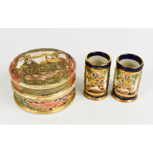 56 - A pair of Meiji period Satsuma miniature vases, of cylindrical form with flared bases, each with a p... 