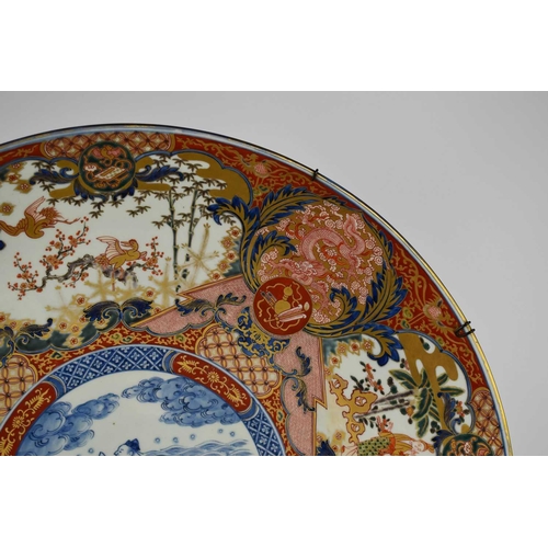 6 - A very large early 19th century Japanese Imari charger, the central blue and white roundel decorated... 