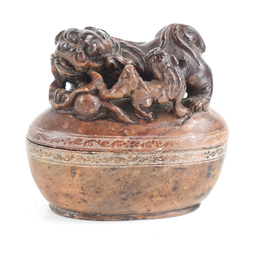 93 - A Chinese soapstone box and cover of oval form the top carved with two dogs of Fo, and a flaming pea... 