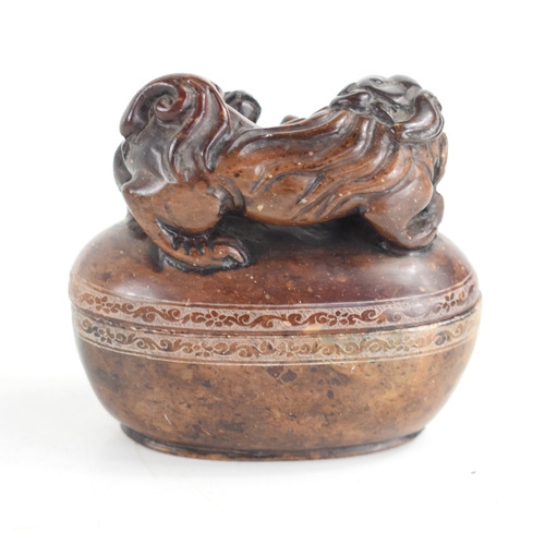 93 - A Chinese soapstone box and cover of oval form the top carved with two dogs of Fo, and a flaming pea... 