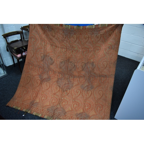 176 - A 19th century wool Paisley shawl, 182 by 171cm and a later peach silk piano shawl with fringe.