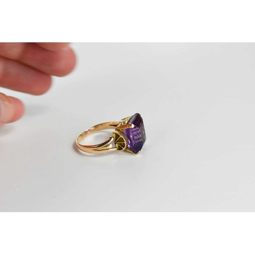 100 - A 9ct gold and amethyst set dress ring, the large emerald cut amethyst of approximately 13.47 by10.8... 