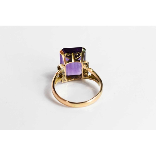 100 - A 9ct gold and amethyst set dress ring, the large emerald cut amethyst of approximately 13.47 by10.8... 