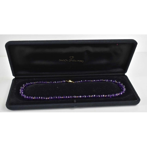 11 - An 18ct gold and amethyst necklace the fifty circular deep violet coloured beads honeycomb cut with ... 