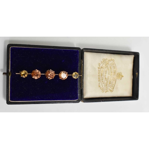 12 - A pale pink sapphire and citrine bar brooch, the central thre rose cut, peach coloured sapphires of ... 