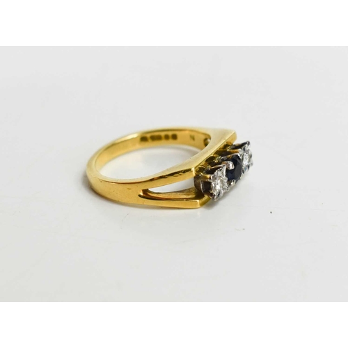 135 - An 18ct gold, diamond and sapphire three stone ring, the central sapphire of approximately 3.7mm, ad... 