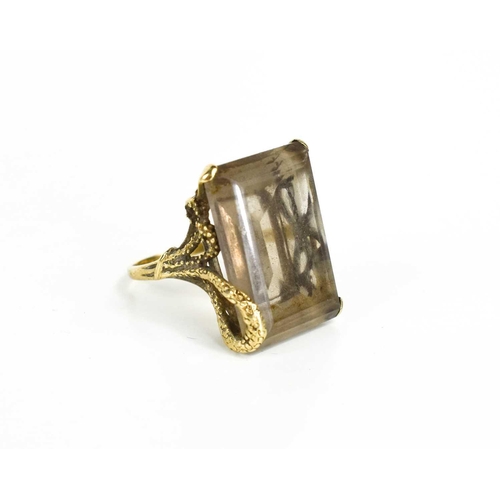 136 - A 9ct gold and smoky quartz dress ring, the quartz measures 2.5 by 2cm, in a four claw setting embel... 